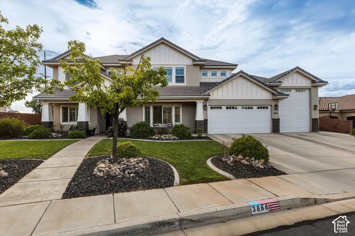 Two-story stucco and board-and-batten exterior with an attached three-car garage