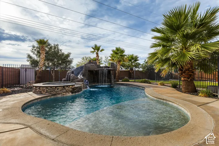 Freeform swimming pool with a rock waterfall feature and integrated spa