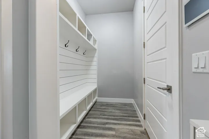 Built-in mudroom storage featuring multiple cubbies, bench seating, and decorative wall hooks
