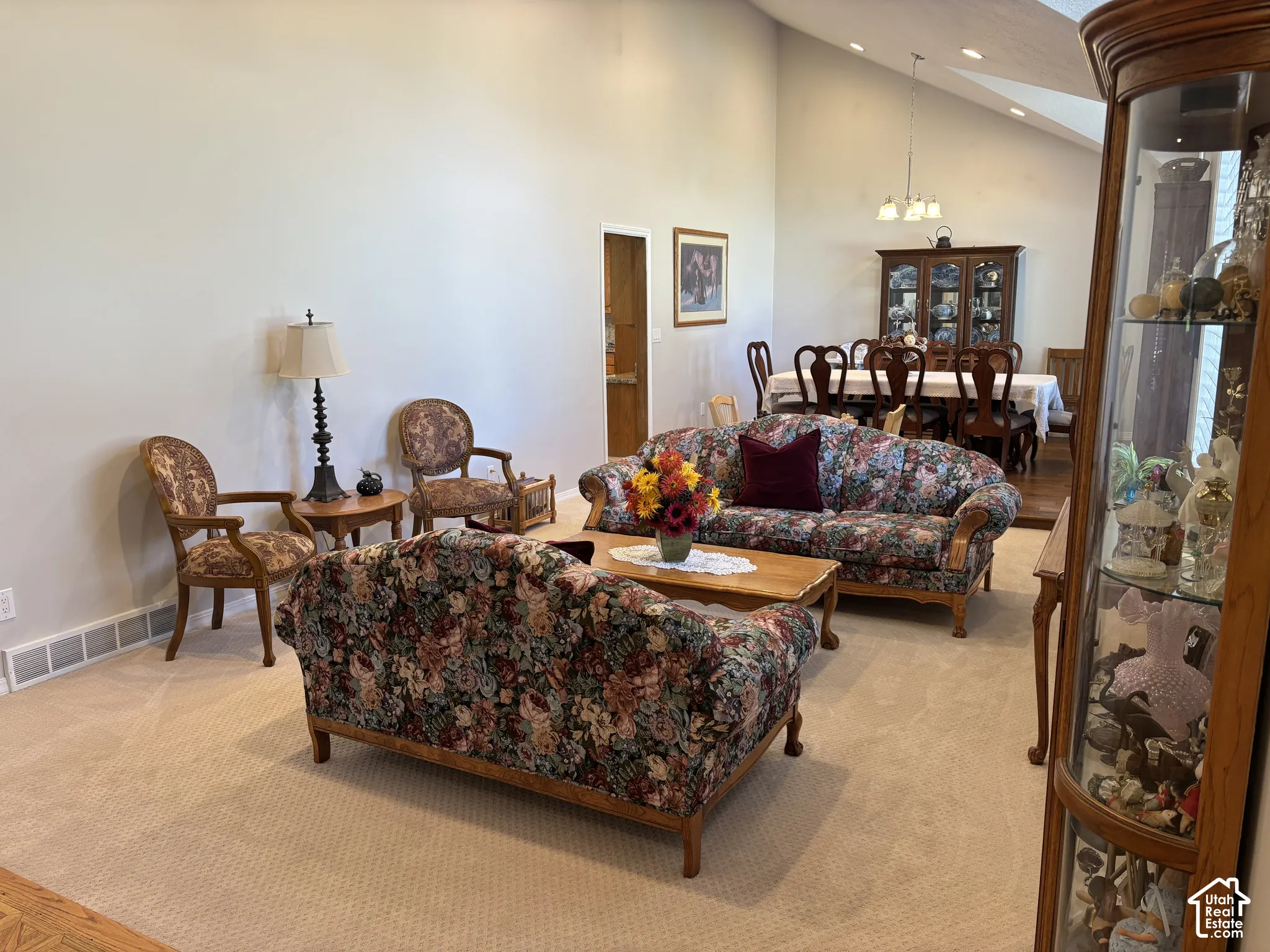 Vaulted ceiling, recessed lighting, chandelier, and carpeted flooring