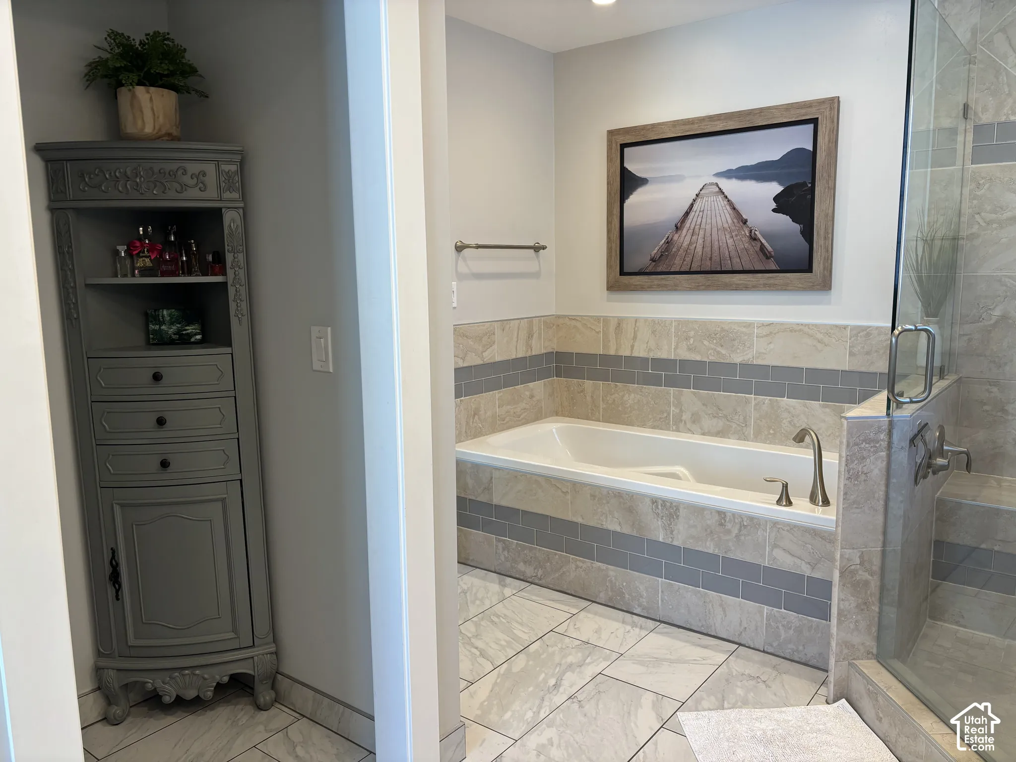 Recessed bathtub with a tiled surround, glass-enclosed shower, and tile flooring