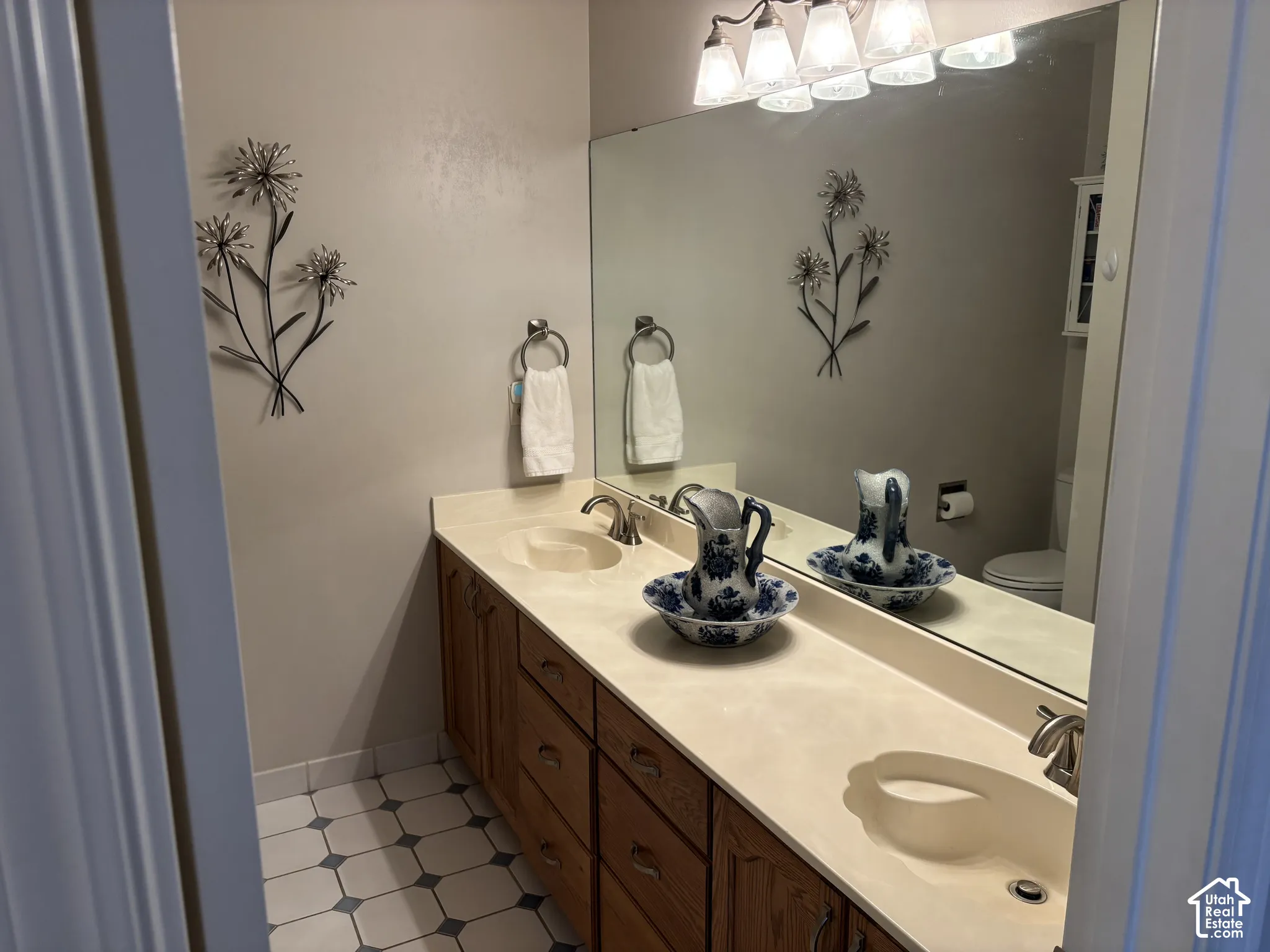 Dual vanity with integrated sinks, wood-finish cabinetry, and a full-width mirror