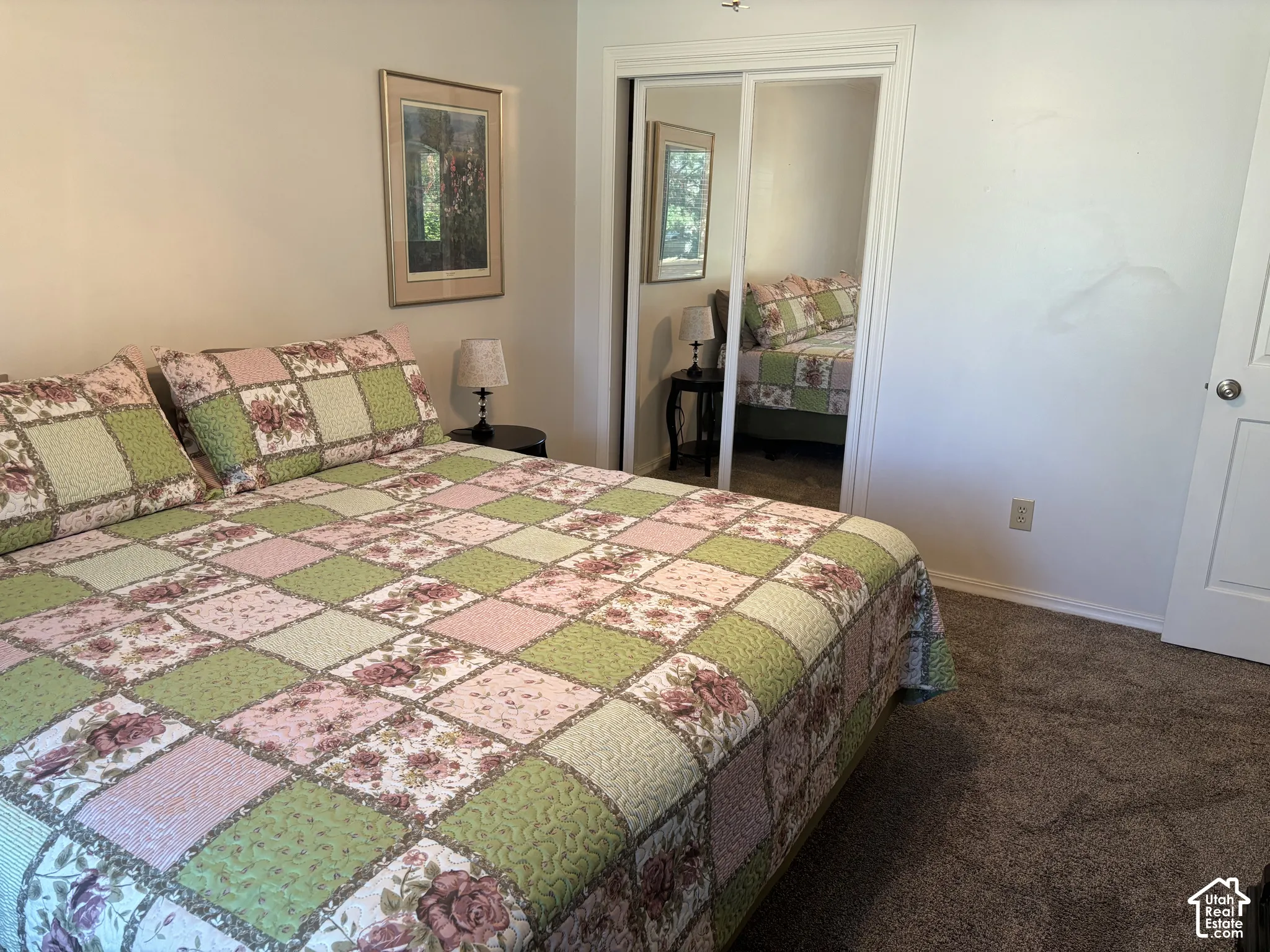 Built-in mirrored closet doors, neutral wall paint, and dark plush carpeting