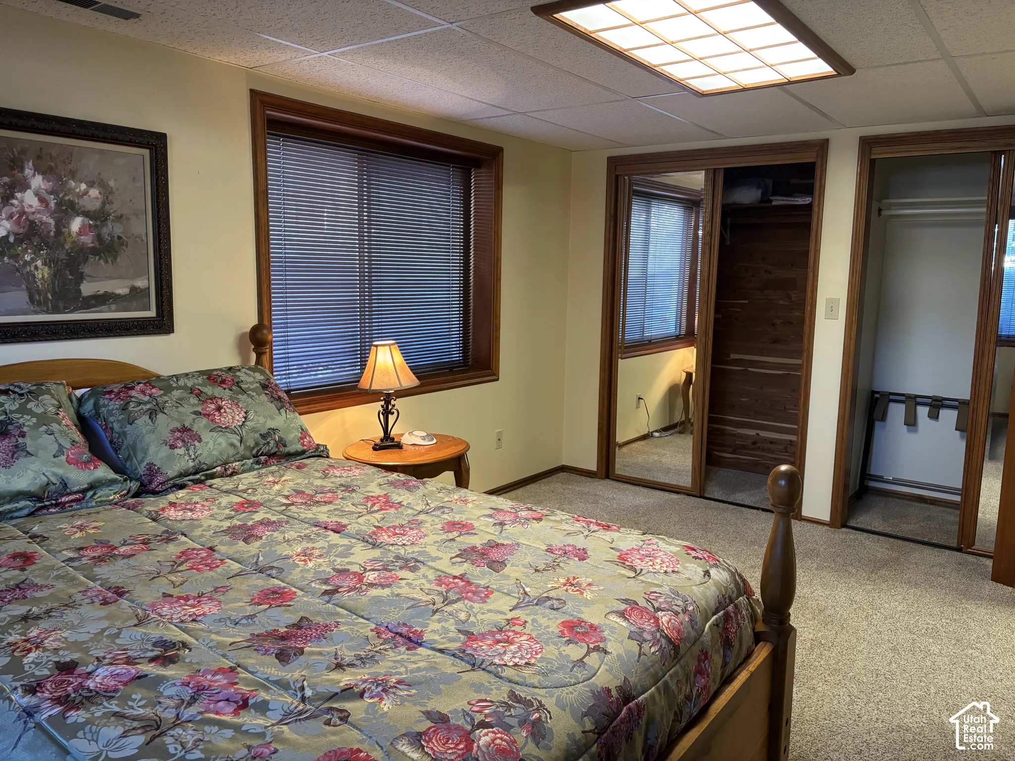 Wall-to-wall carpeting with wood-framed window, and mirrored closet doors