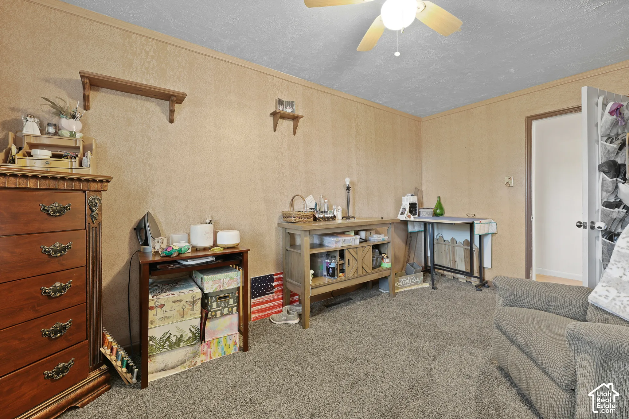 Wall-to-wall carpeting with light-toned wall paneling and a ceiling fan