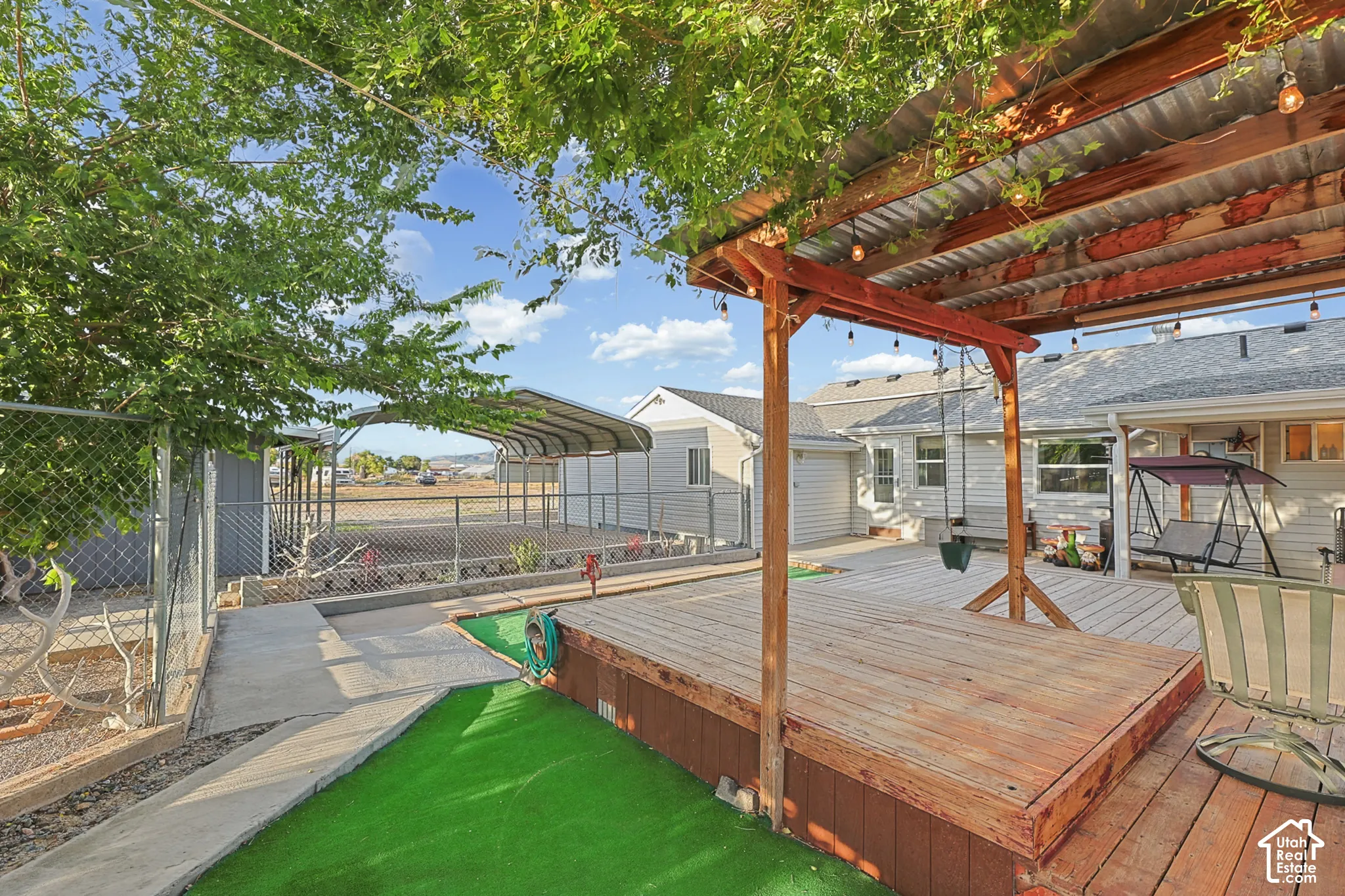 Expansive wood deck with a built-in pergola featuring a corrugated metal roof
