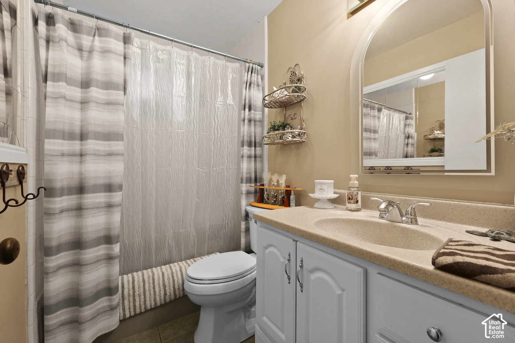 Vanity with light-toned countertop, white cabinetry, and polished chrome faucet