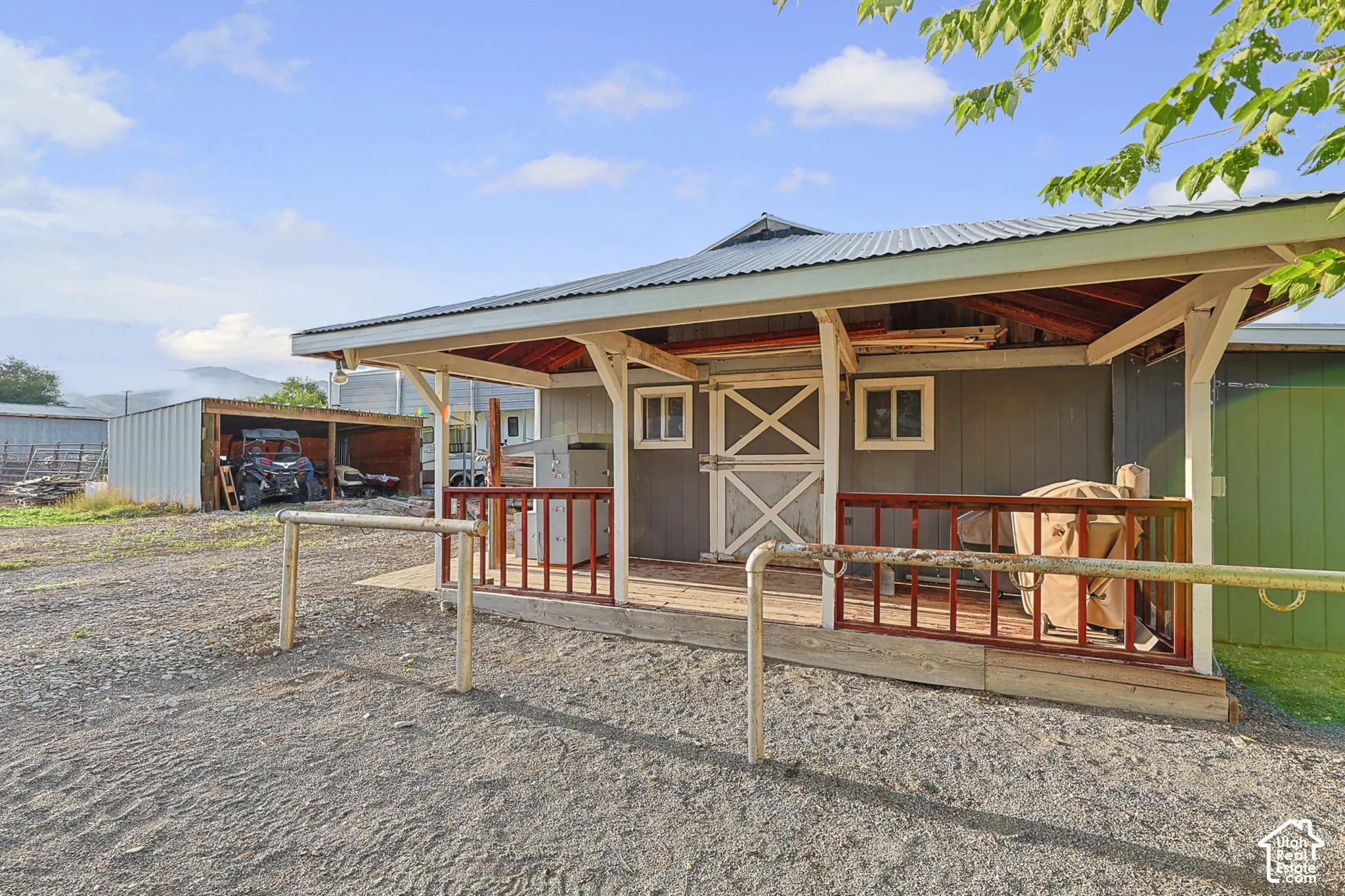 Corrugated metal roof, wood-paneled ceiling, wood-finish porch railing, Dutch door, and a permanent covered structure