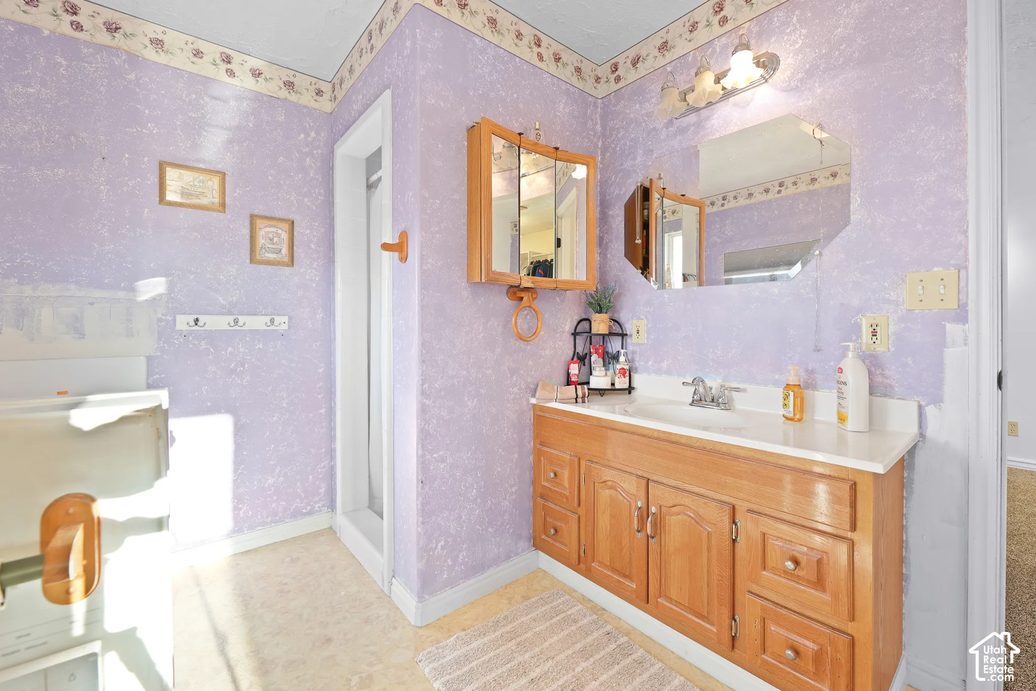 Vanity with a white countertop and integrated sink, a wall-mounted medicine cabinet, and an overhead light fixture