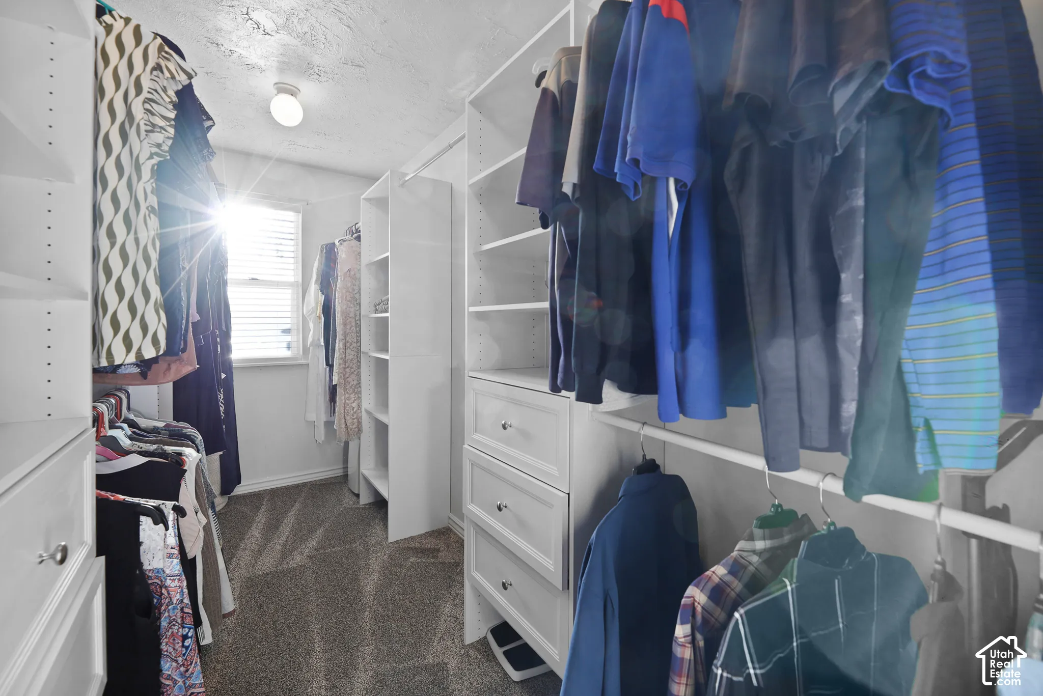 Walk-in closet featuring built-in shelving, hanging rods, pull-out drawers, a window with blinds, and recessed lighting