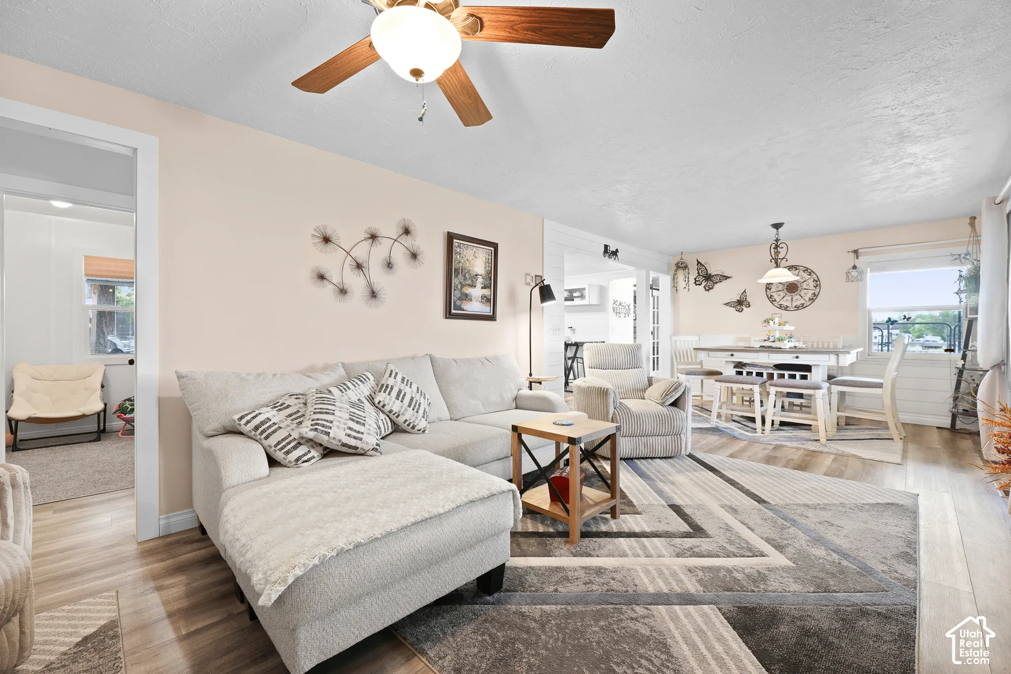 Wood-finish flooring throughout, ceiling fan with integrated lighting, recessed lighting, and a window with blinds