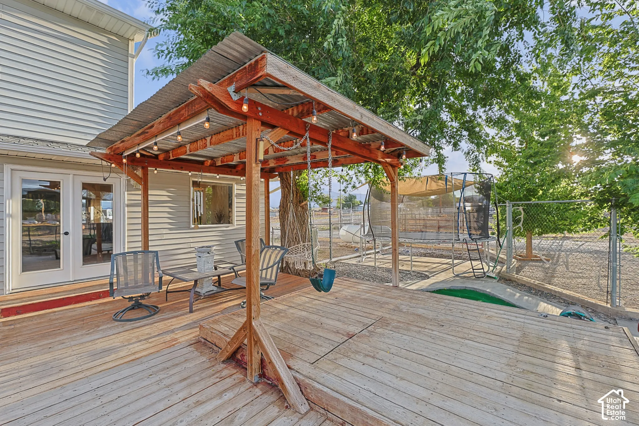 Expansive wood-finish deck with a built-in pergola featuring a corrugated metal roof