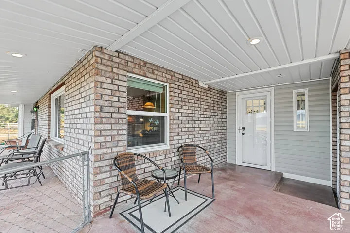 Brick exterior with a covered porch, recessed lighting, and a white entry door with a privacy screen