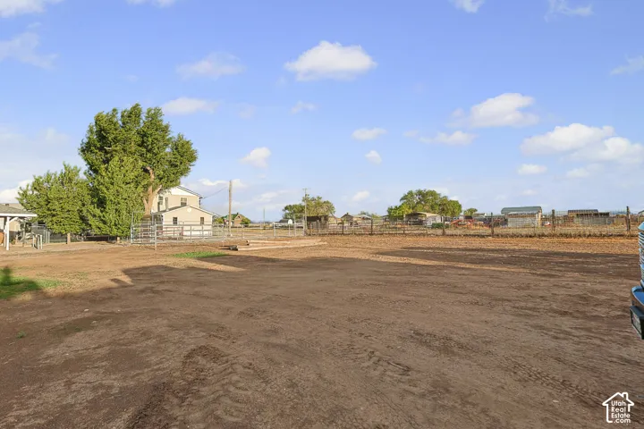 Expansive property featuring a two-story residence, mature trees, and perimeter fencing