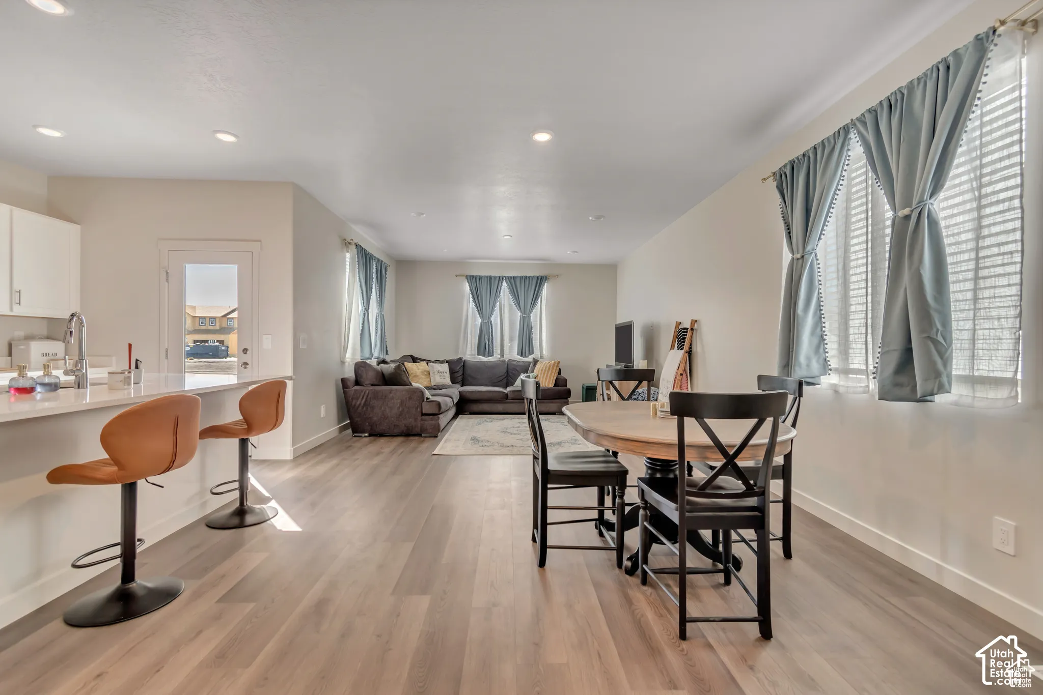 Open-concept living area featuring wood-finish flooring, recessed lighting, and ample natural light