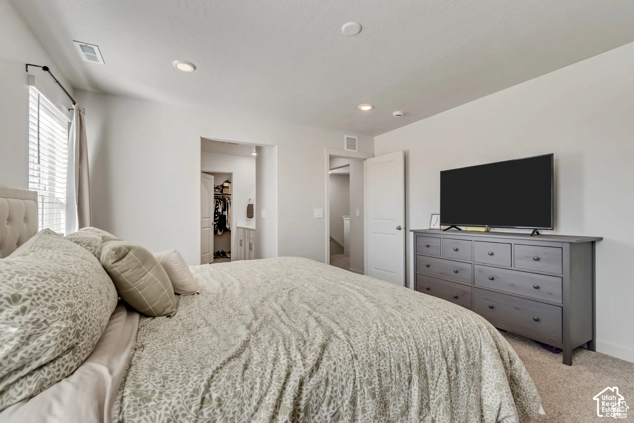 Recessed ceiling lighting, white interior doors, and neutral wall paint