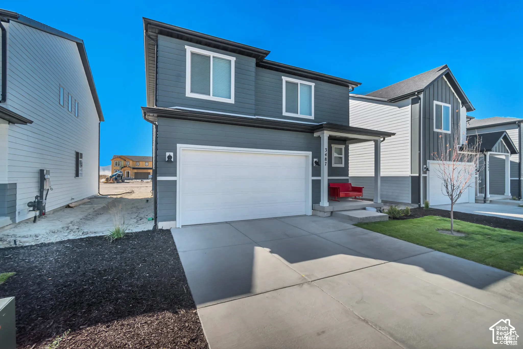 Two-story exterior with dark gray siding and white trim