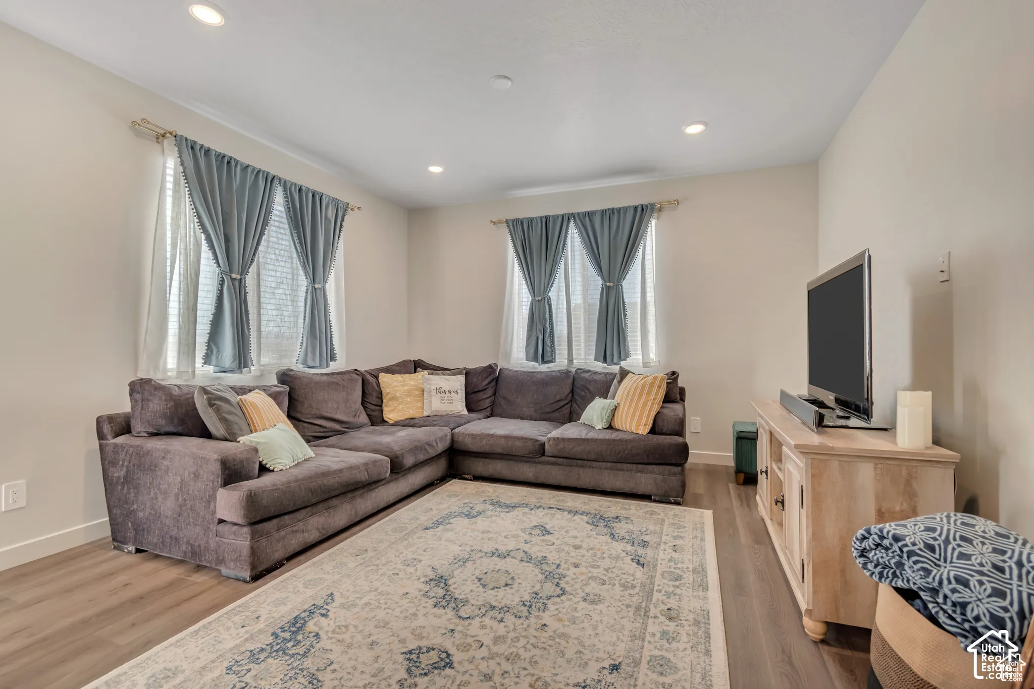 Recessed lighting, wood-finish flooring, and multiple windows with blinds