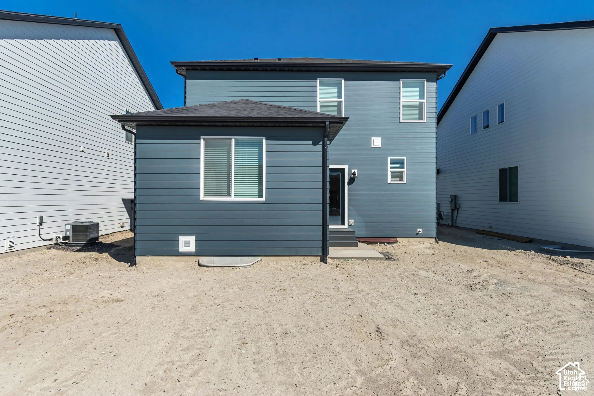 Modern exterior with blue horizontal siding and a dark-toned roof
