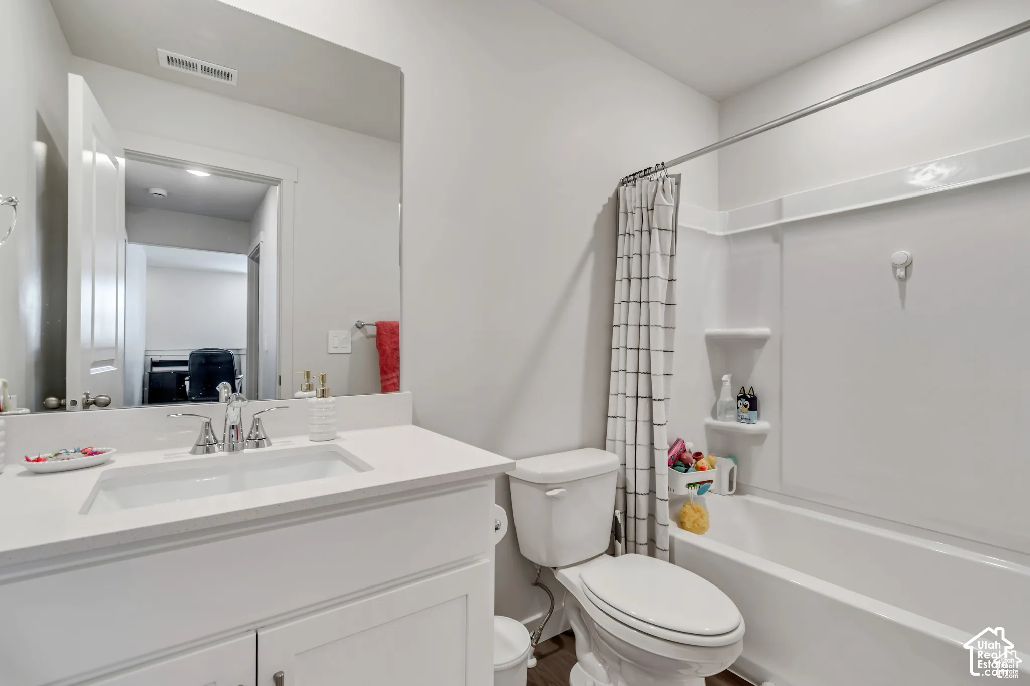 White vanity with a rectangular undermount sink, a polished chrome faucet, and a large wall-mounted mirror