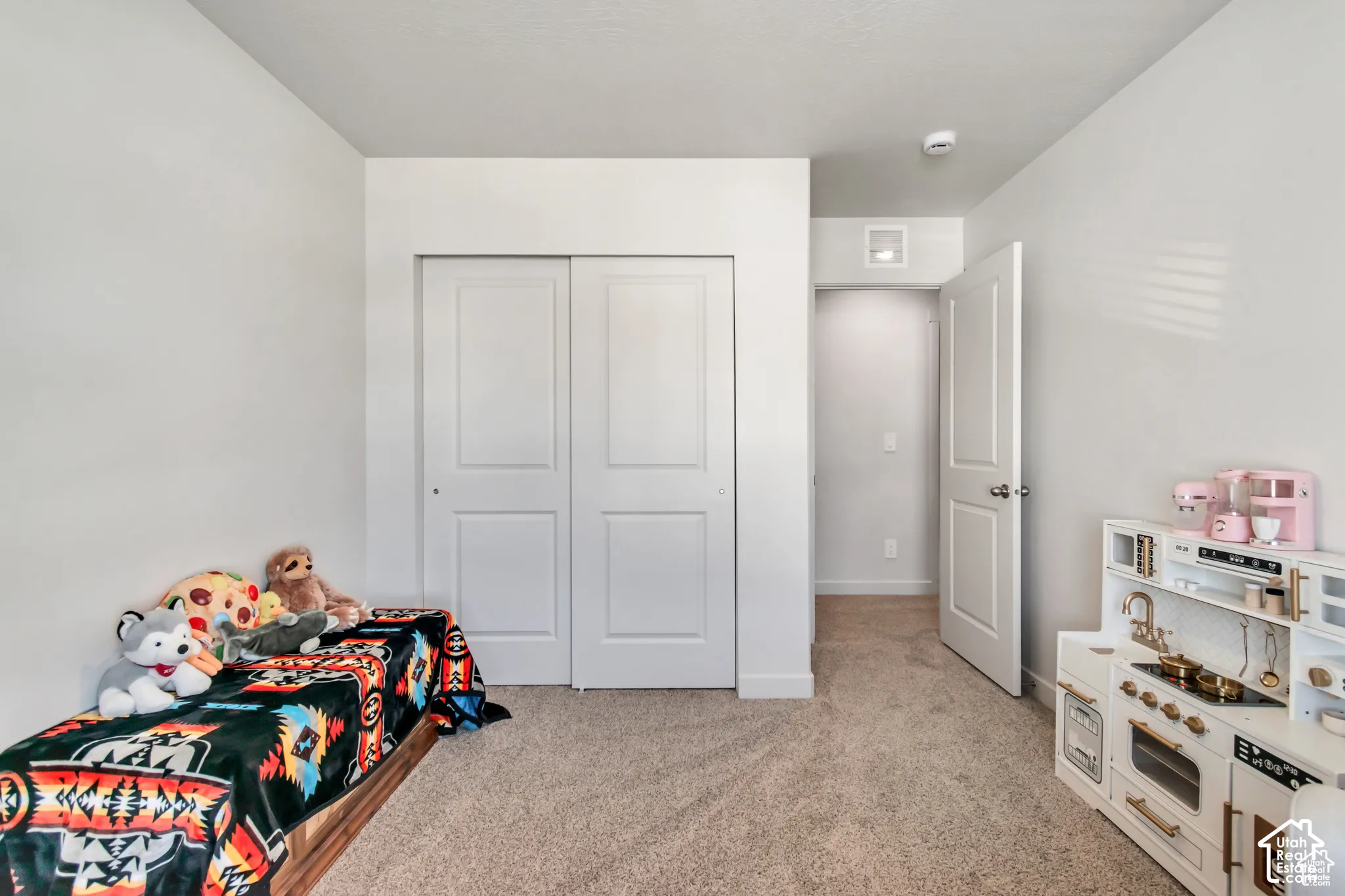 Neutral wall tones, carpeted flooring, sliding closet doors, and recessed lighting