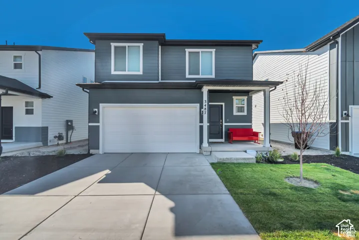 Contemporary two-story exterior with horizontal siding, covered entry, attached garage, and concrete driveway