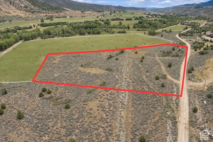 Expansive undeveloped land featuring natural scrub brush and surrounding mountainous terrain