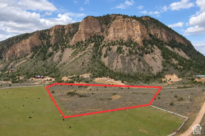 Expansive land parcel with surrounding mountainous terrain, natural vegetation, and a partially graded dirt road