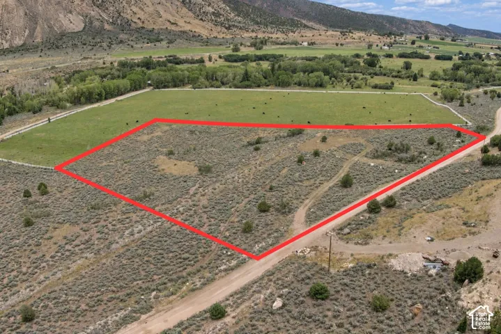 Expansive rural parcel featuring natural ground cover and surrounding mountainous landscape