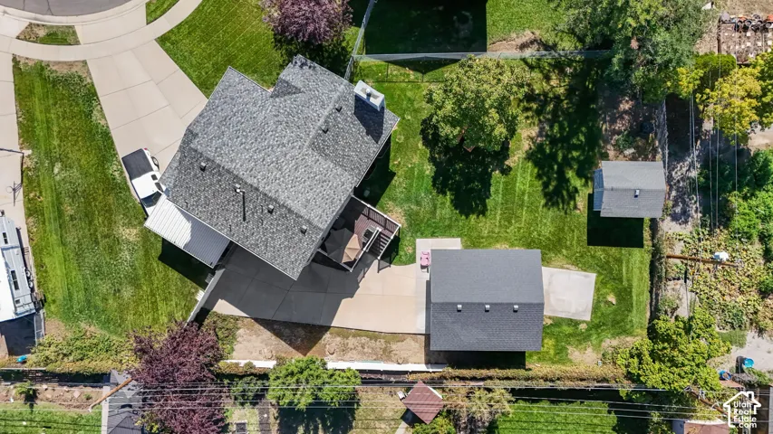 Expansive property featuring a concrete driveway, a multi-level deck, an accessory dwelling unit with a gray shingle roof, and an additional shed