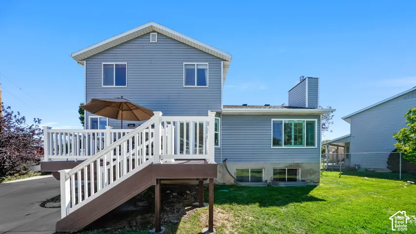 Two-story property with siding exterior, multi-level deck, and expansive green lawn