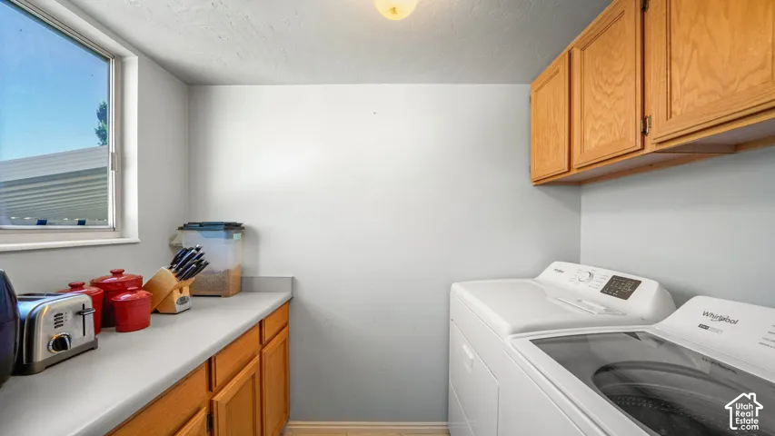 Laundry area featuring wood-finish base cabinets, white countertops, and upper cabinetry