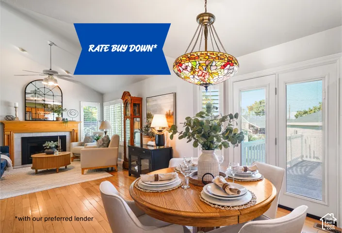 Vaulted ceilings, wood-finish flooring, fireplace with a mantel, stained glass chandelier, and dual glass pane doors