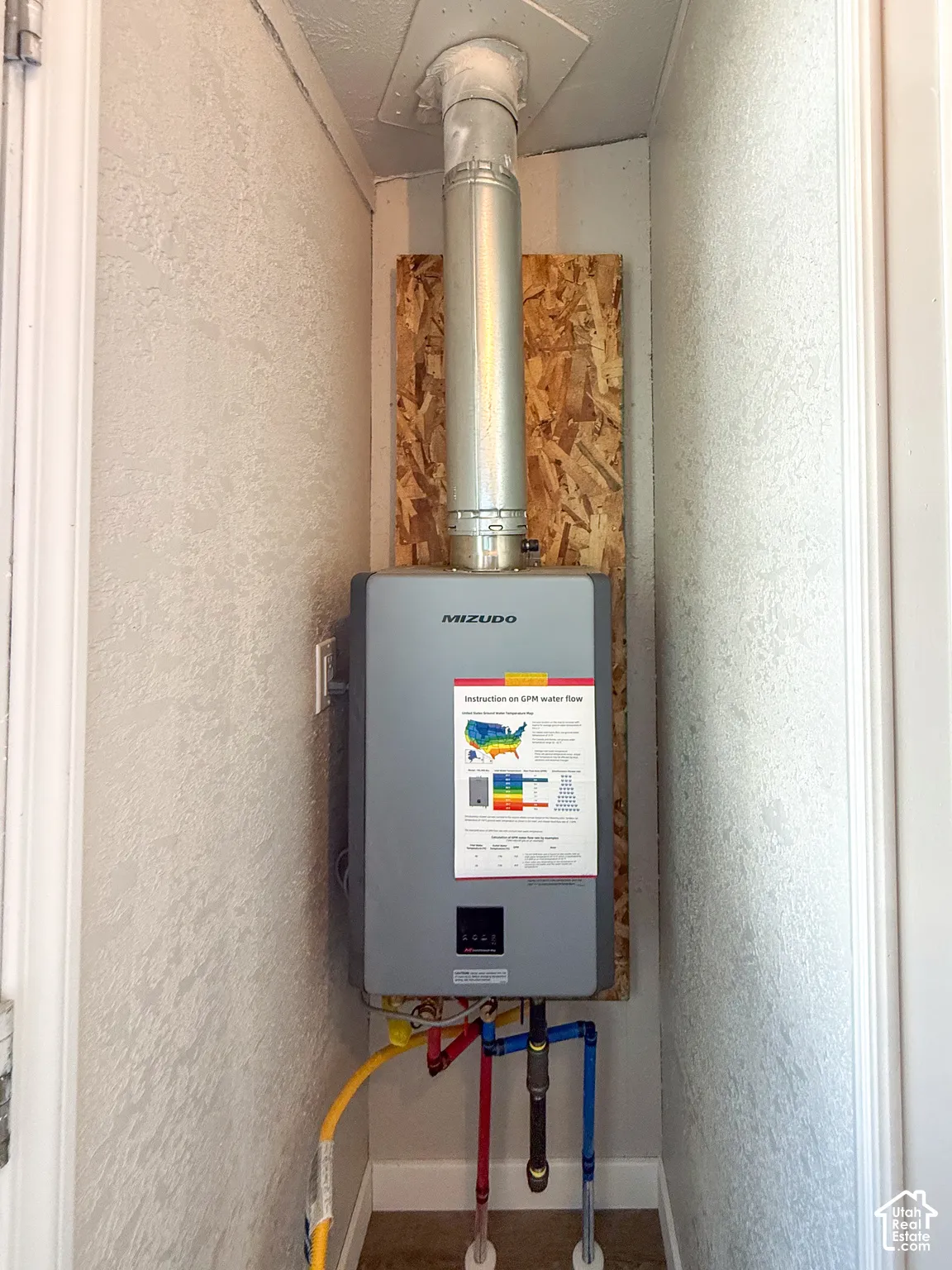 Mizudo tankless water heater with visible gas line and water connections