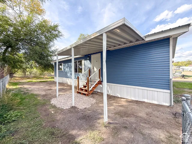 Blue horizontal siding with white trim, covered entry, and wood steps with white railings