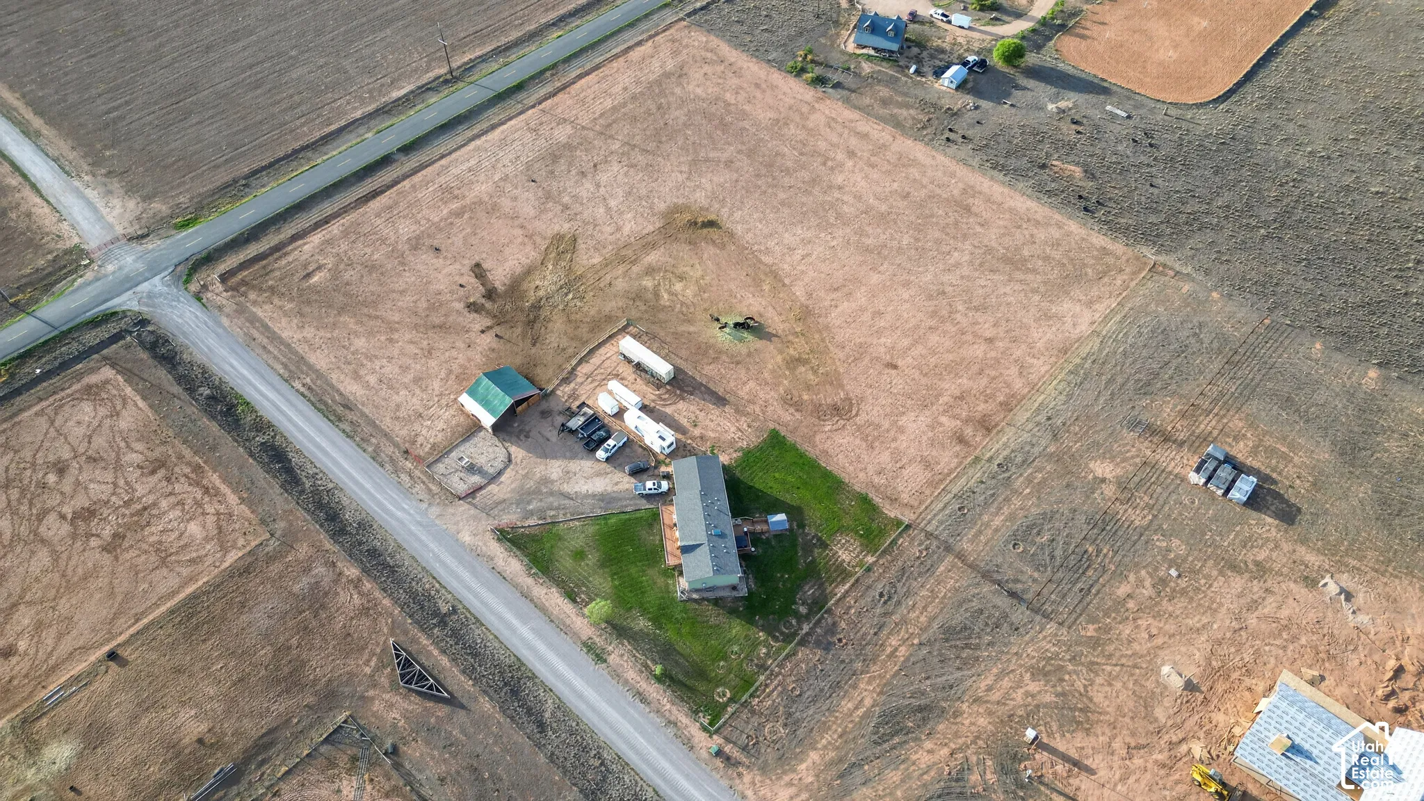 Extensive surrounding acreage with a central residential structure, accompanying outbuilding, and direct road access