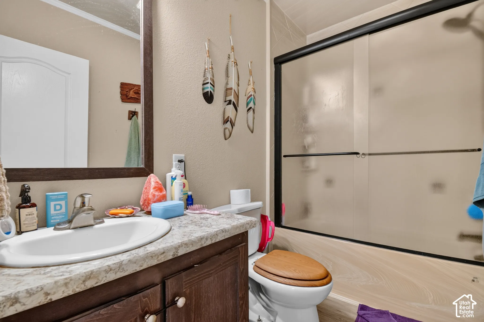 Bathroom with a vanity, single basin sink, and a shower with sliding frosted glass doors