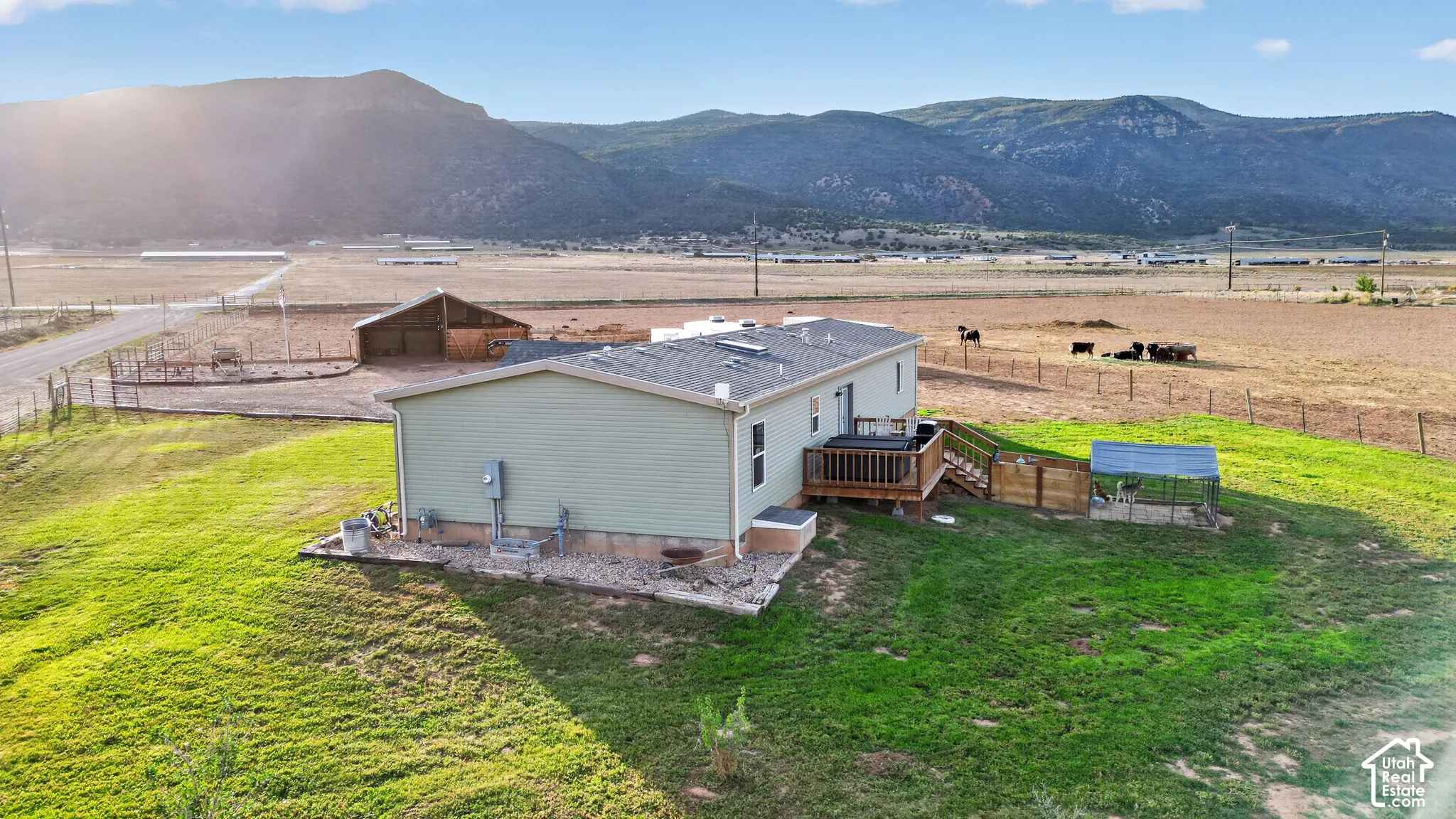 Expansive property featuring a detached barn, a wooden deck, and mountain backdrop