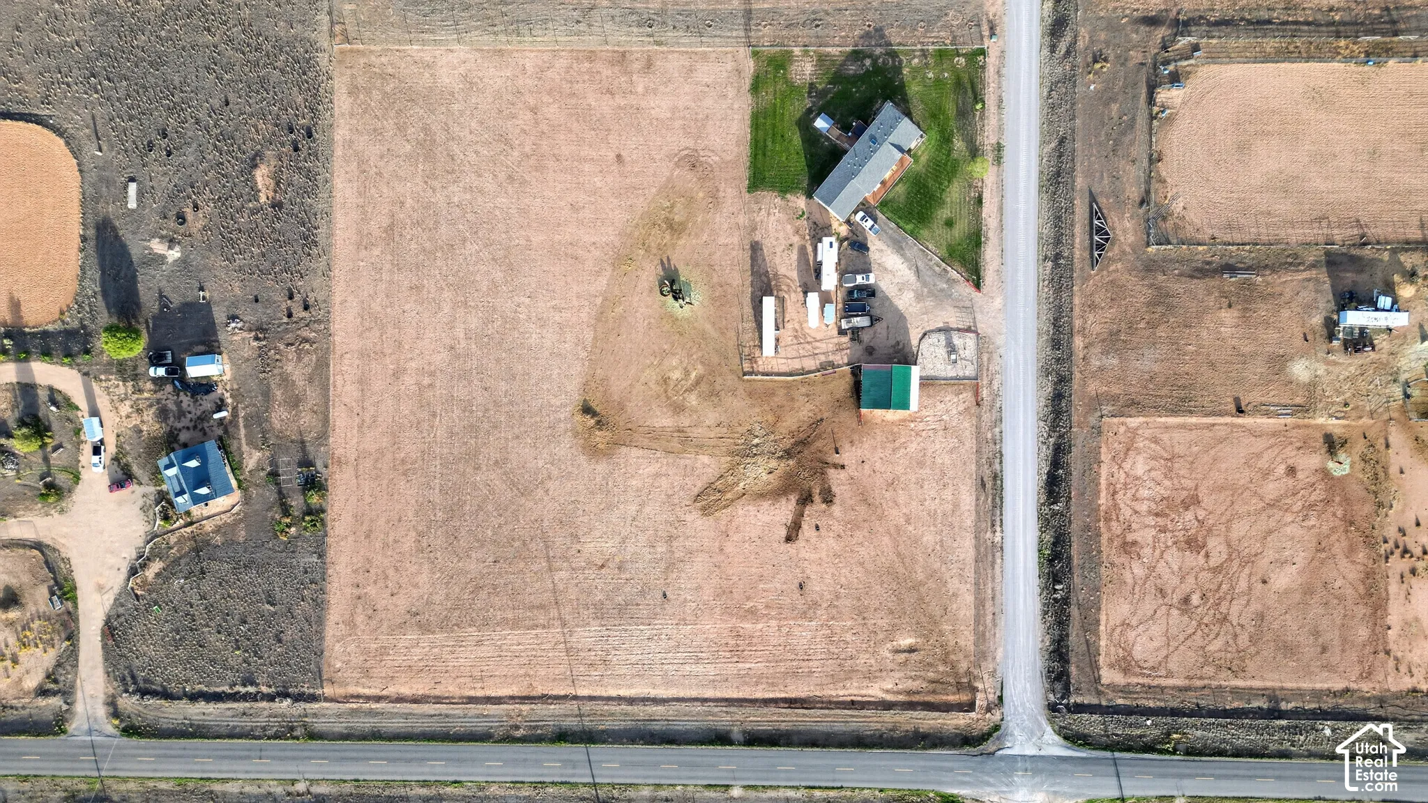 Expansive rural property featuring multiple outbuildings, a detached garage, and direct access to a paved road