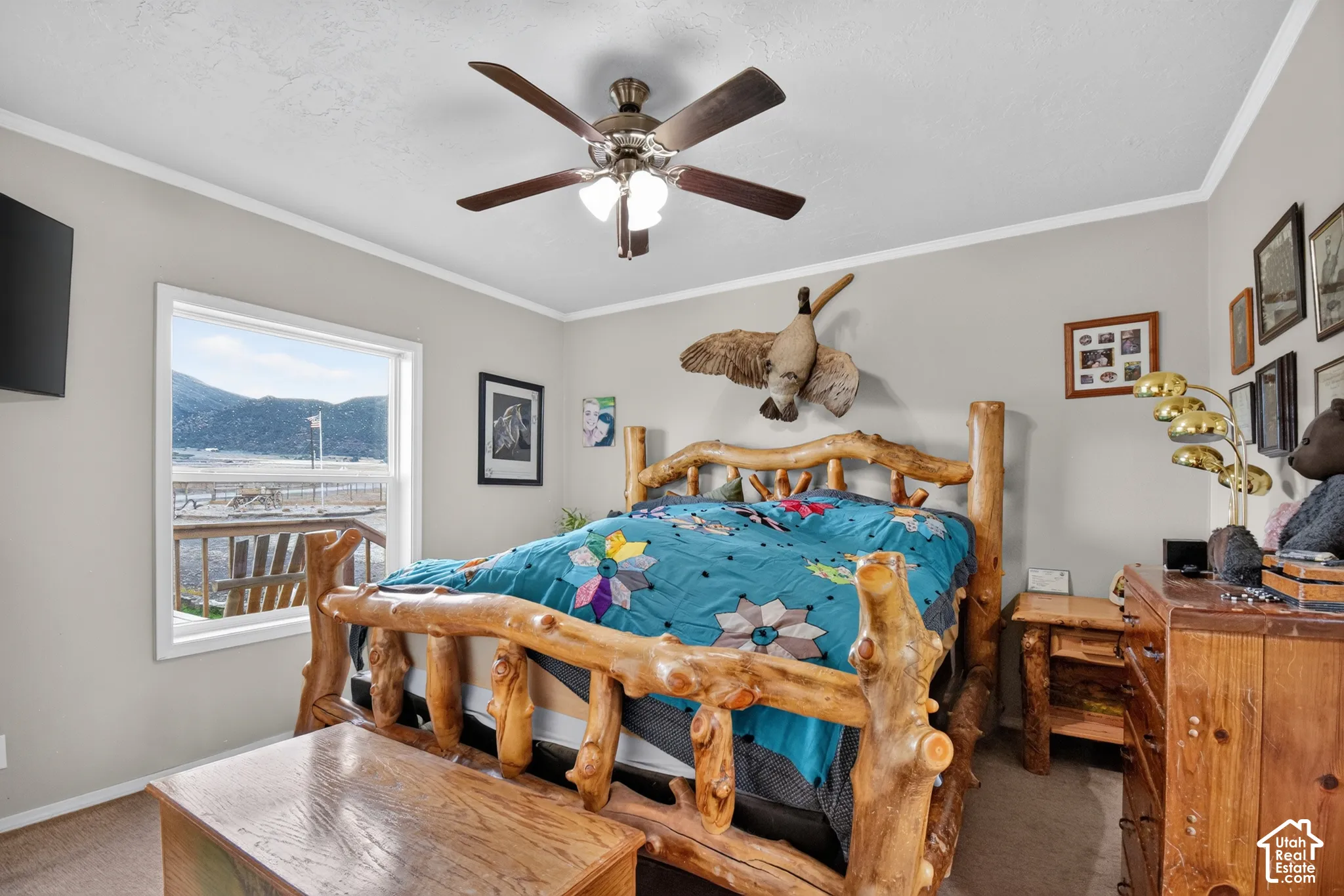 Spacious room featuring a ceiling fan, crown molding, and a window offering an expansive outdoor scene