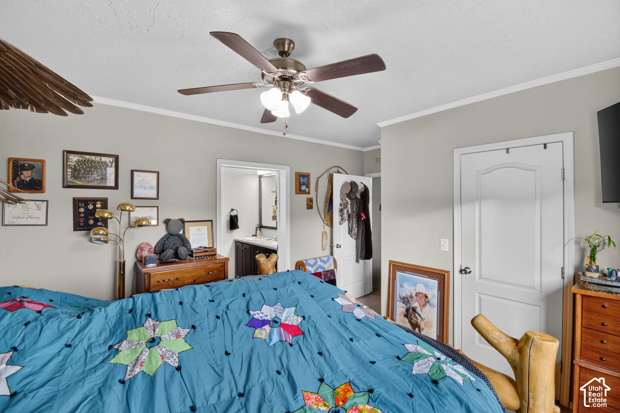 Ceiling fan with integrated lighting, crown molding, white paneled interior doors, and a visible vanity with a dark wood-finish cabinet
