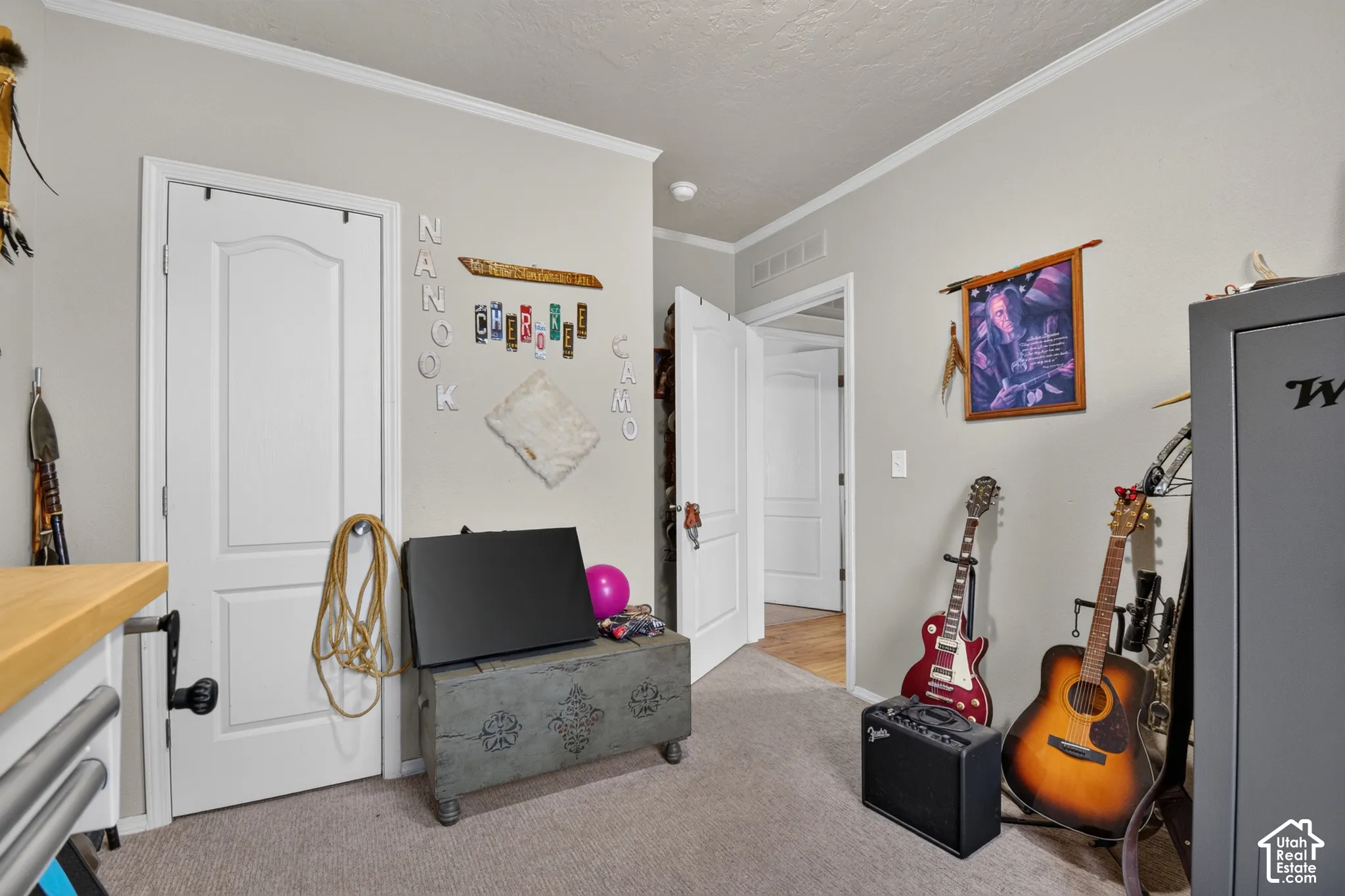 White interior doors, crown molding, light neutral wall color, and carpeted flooring
