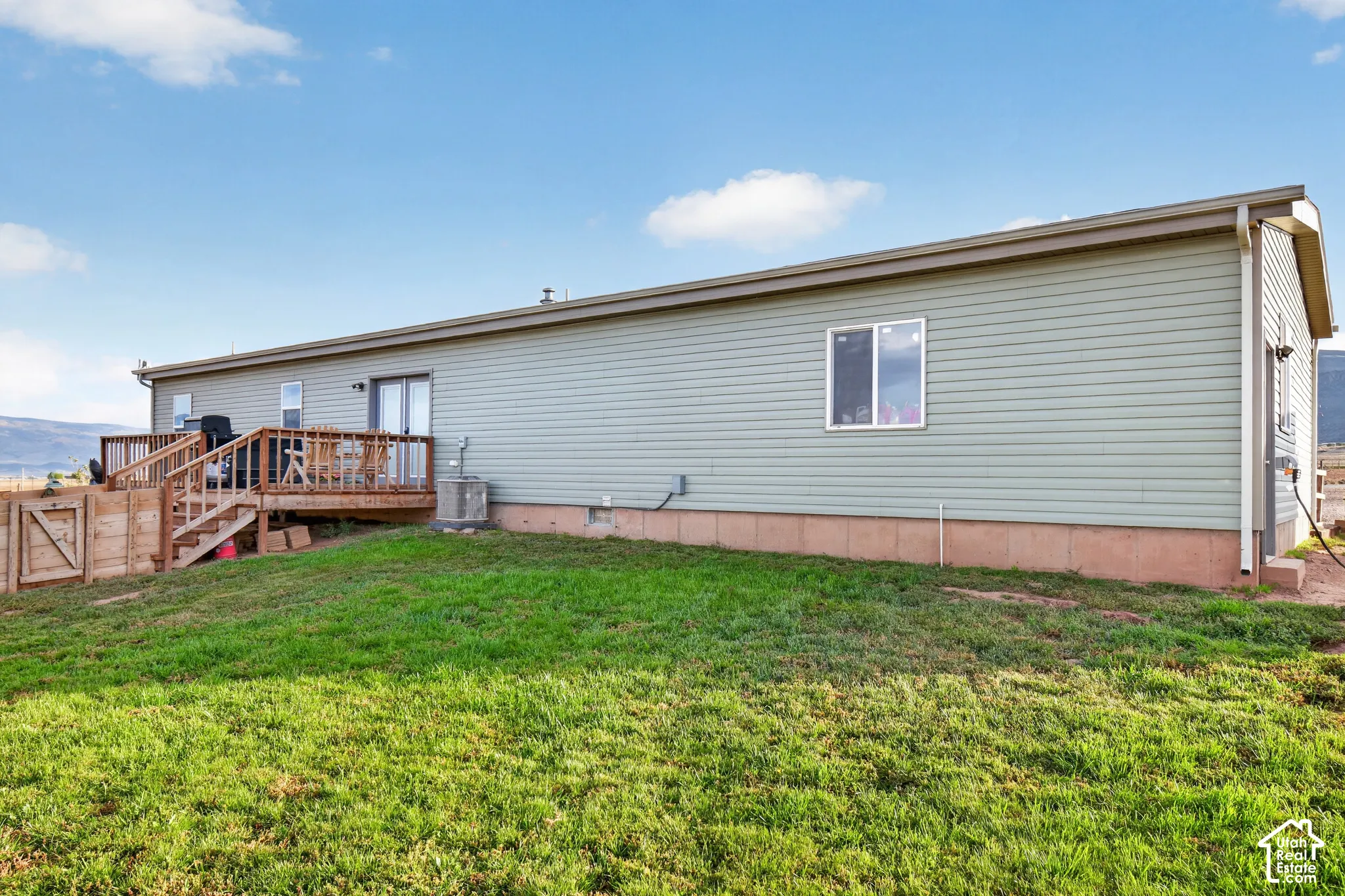 Exterior featuring horizontal siding, a sliding glass door, an outdoor deck with wood railings, and a single-hung window