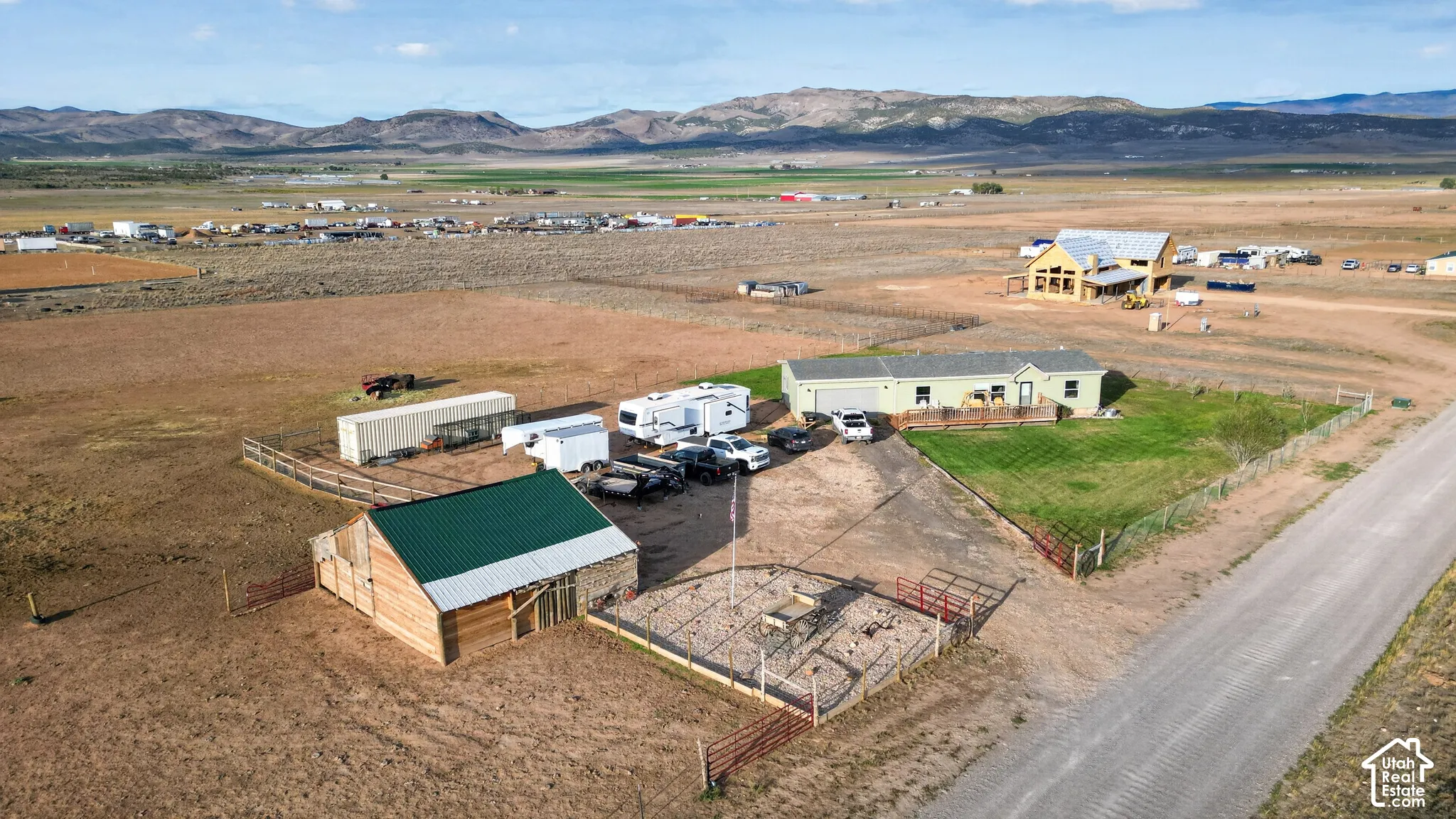 Ranch property with expansive land, a green-roofed barn, and a fenced area