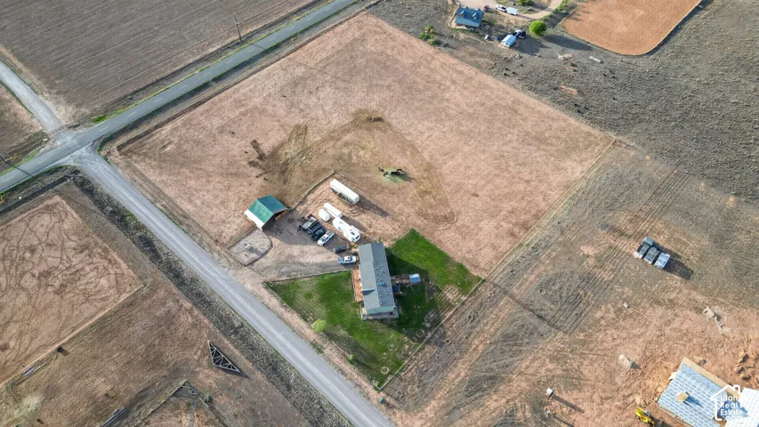 Extensive surrounding acreage with a central residential structure, accompanying outbuilding, and direct road access