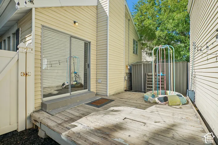 Private outdoor decking featuring a sliding glass door and perimeter fencing