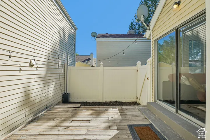 Private outdoor deck area featuring wood decking and a privacy fence