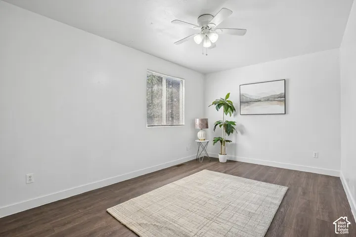 Recessed window, wood-finish flooring, white walls, and a ceiling fan with integrated lighting