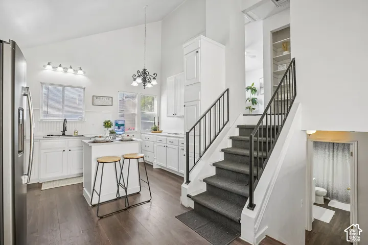 Kitchen featuring wood-finish flooring, white cabinetry, a central island, and stainless steel appliances