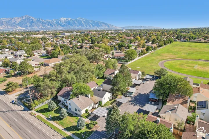 Expansive mountain backdrop, established neighborhood setting, mature trees, adjacent green space, and paved roadways
